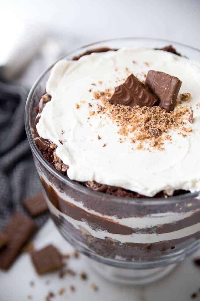 Triple chocolate trifle layered with chocolate cake, whipped cream, chocolate pudding, and chunks of health bar,