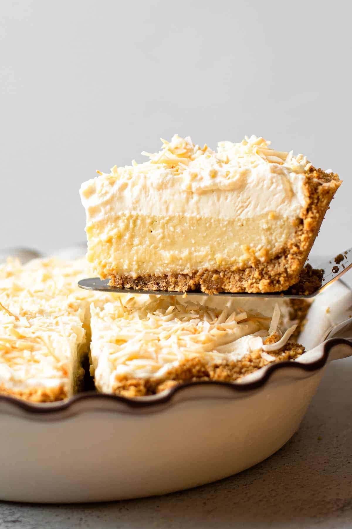 A slice of coconut cream pie picked with a pie server.