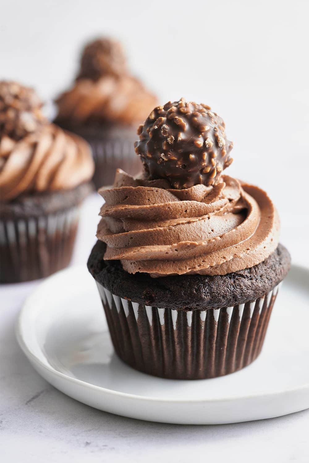 Chocolate cupcakes topped with chocolate frosting and a piece Ferrero Roche. 
