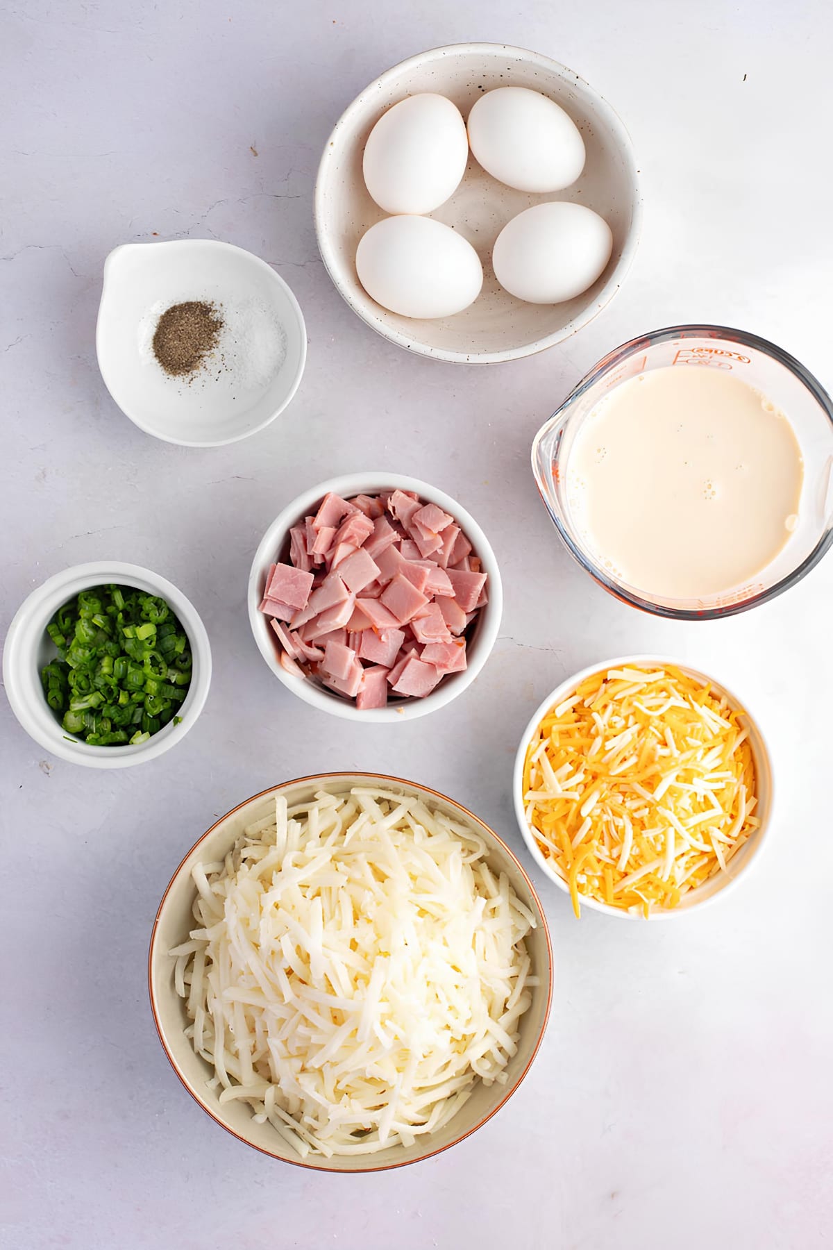 Farmer's Casserole Ingredients: Hash Brown Potatoes, Cheese, Ham, Green Onions, Milk, Eggs, Salt and Pepper