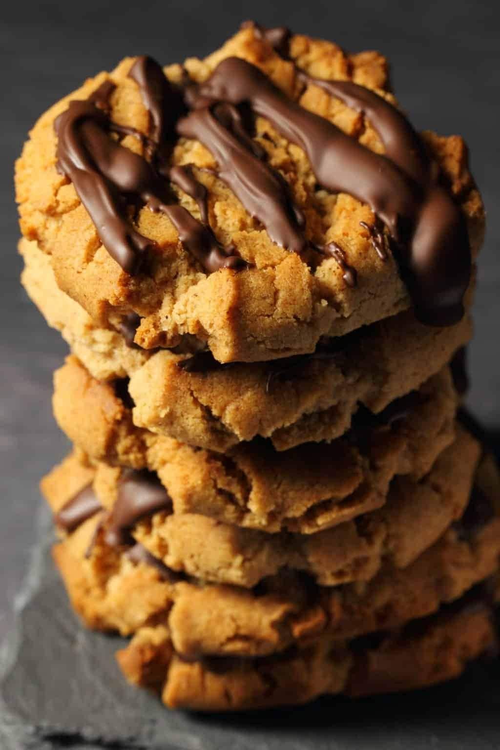 Stacked almond butter cookies with drizzle of chocolate syrup on top,