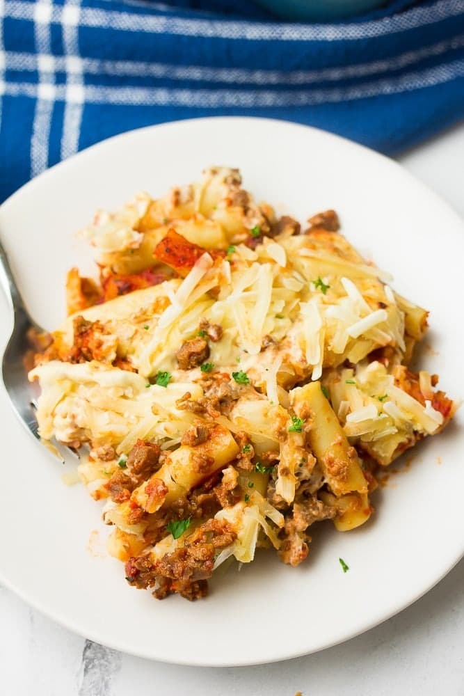 Ziti with sauce, parmesan cheese and chopped parsley leaves.