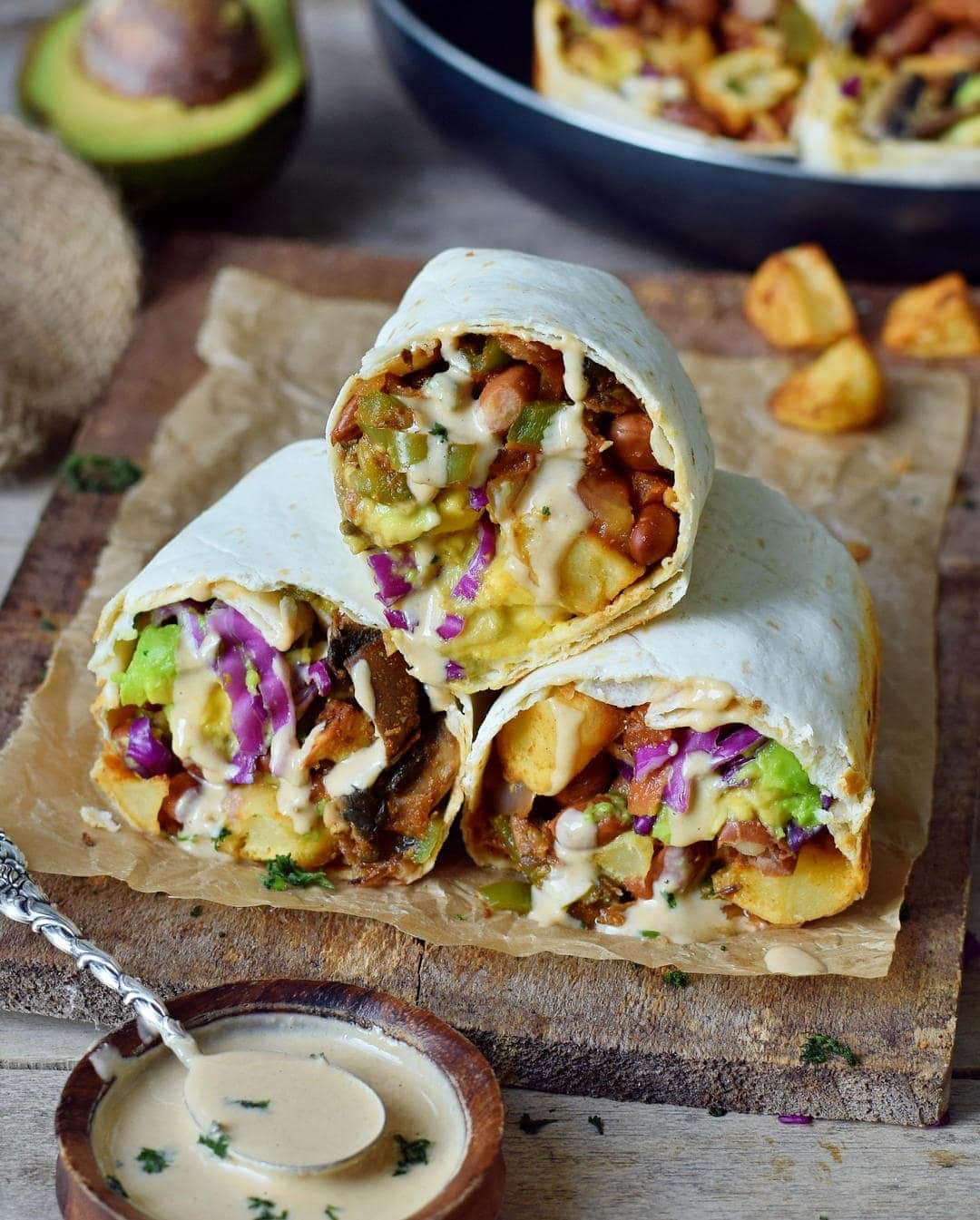 Sliced burritos loaded with roasted potatoes, avocado, mushrooms, and peppers.
