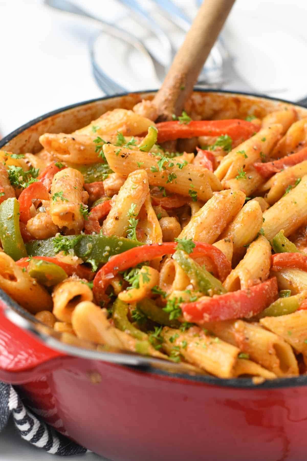 Pasta in cajun sauce with tomatoes, red and green peppers with cheese on a pot. 
