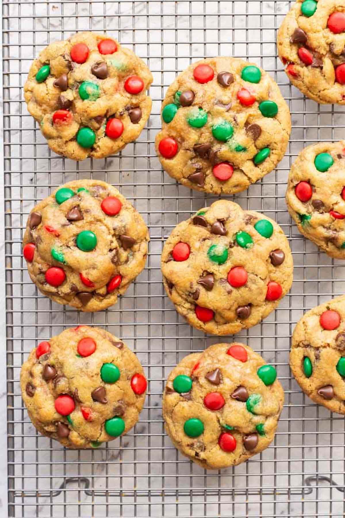 Chocolate cookies with M&Ms topping on a cooling rack. 