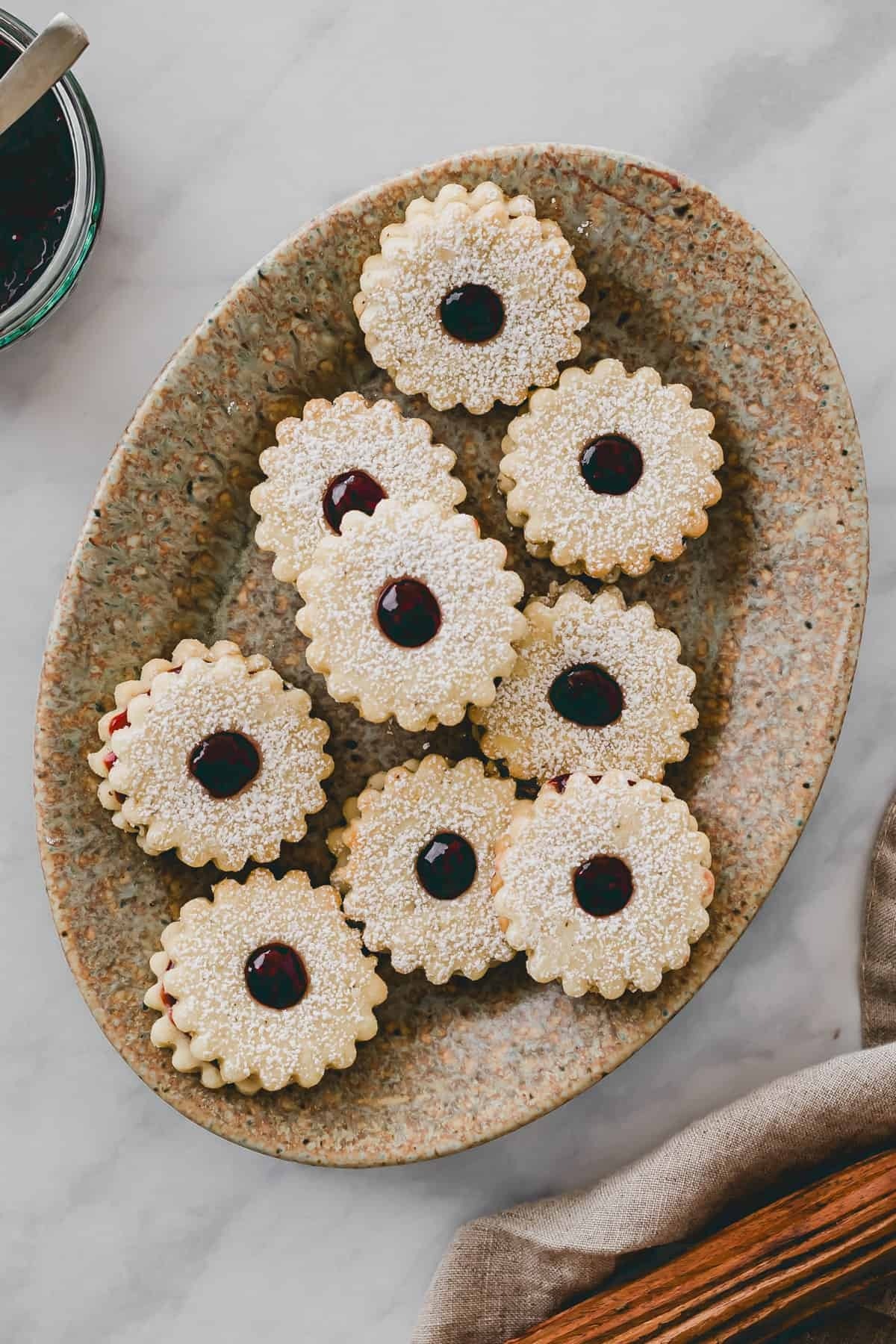 Powdered sugar coated Linzer cookies with raspberry jam filling. 