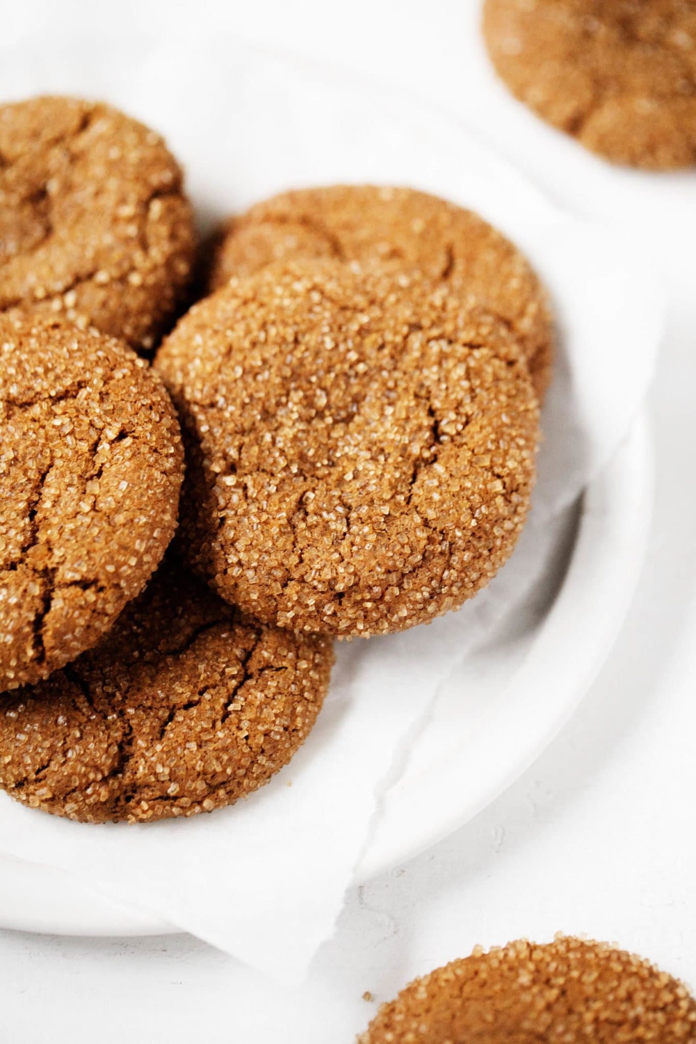 Bunch of gingerbread cookies coated with brown sugar on plate. 