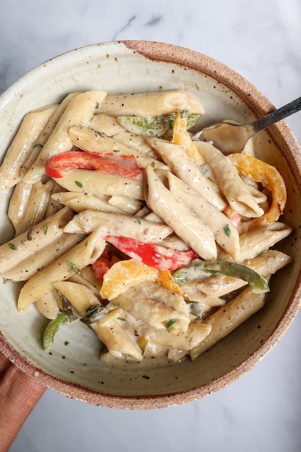 Penne pasta with creamy sauce and three color of peppers.