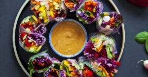 Healthy Homemade Vegetable Spring Rolls with Peanut Sauce in a Black Plate