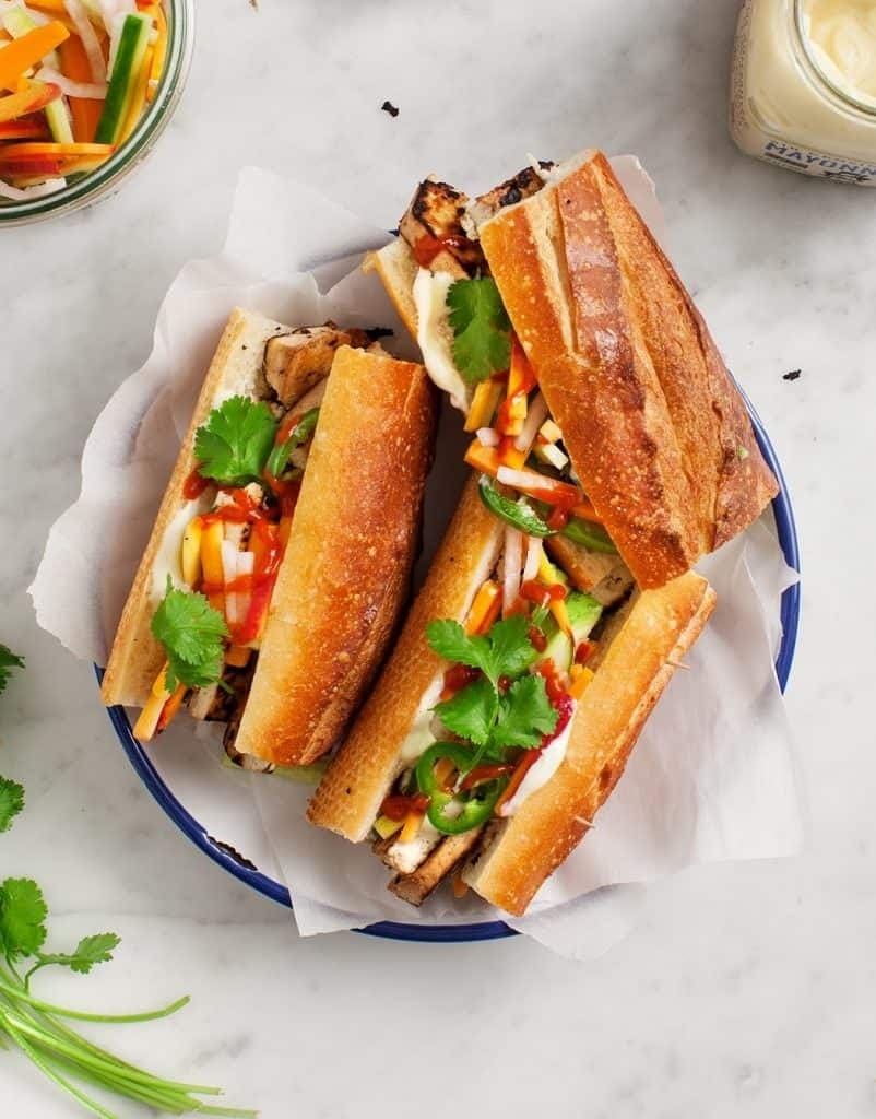 Baguette sandwich with  spicy mayo, tofu slices, pickled veggies, and cilantro.