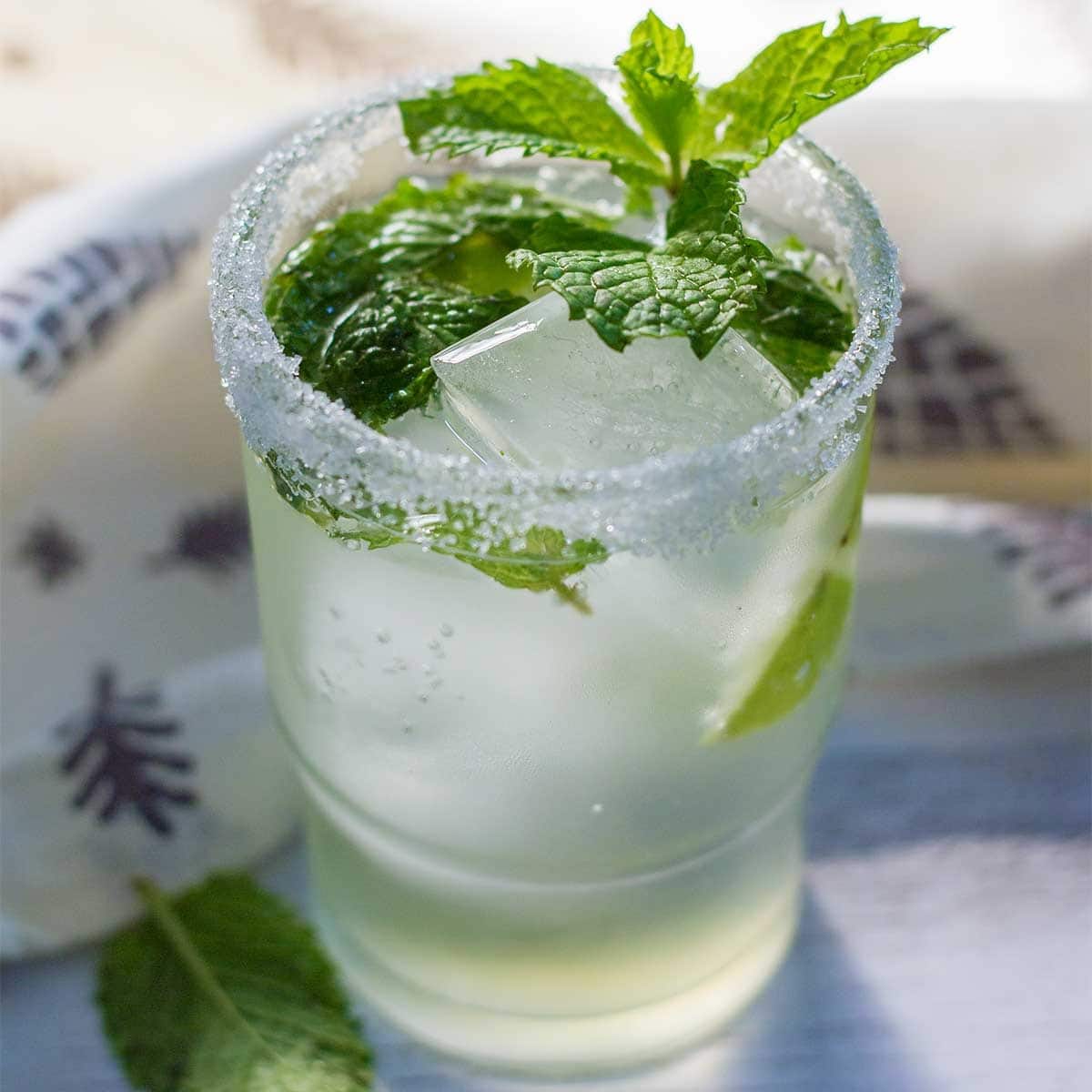 A refreshing mojito cocktail, garnished with fresh mint leaves and served over ice. 
