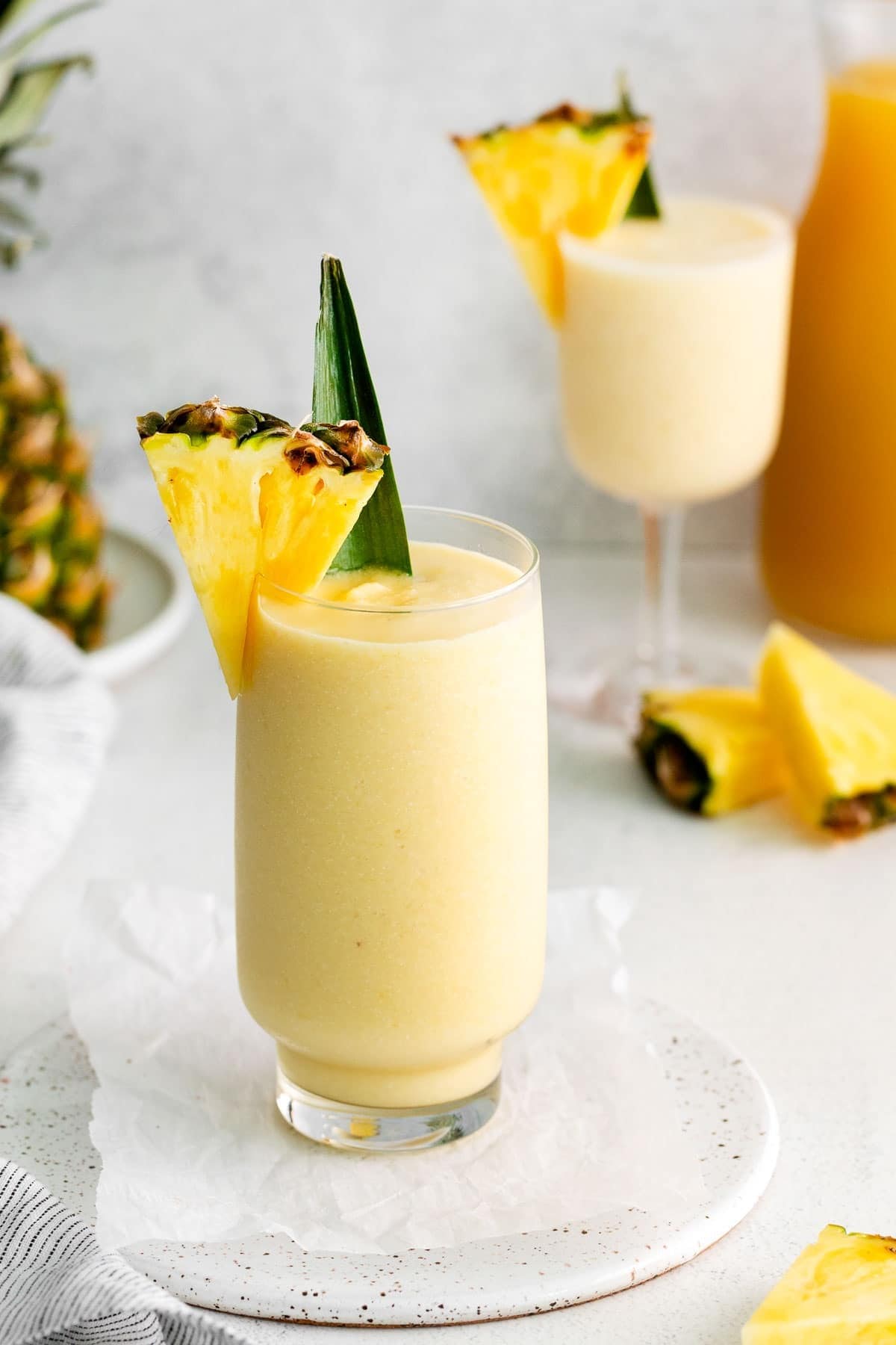Pina Colada in a tall glass garnished with pineapple slice.