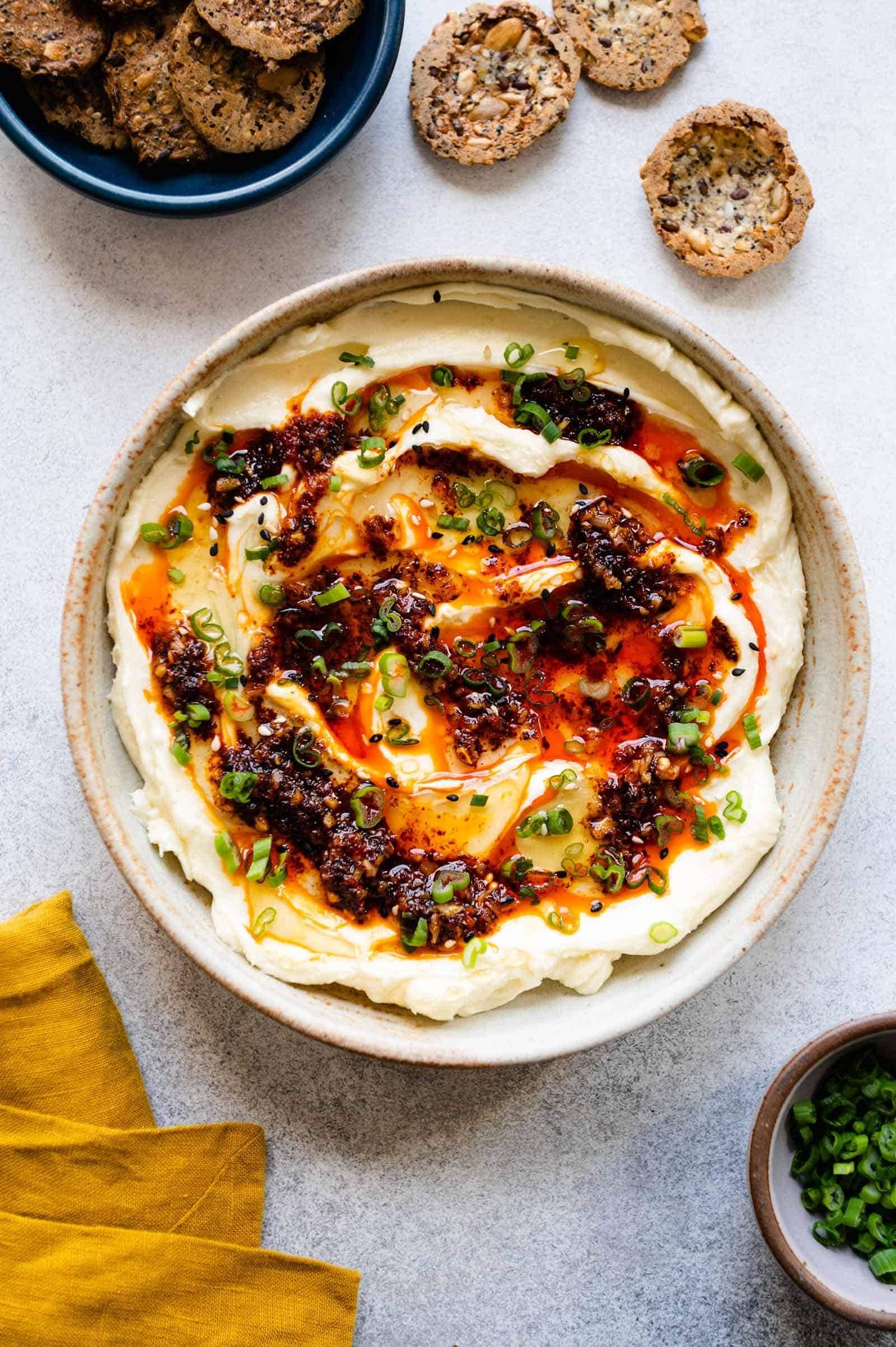 Whipped brie on a bowl topped cheese with honey and chili oil.