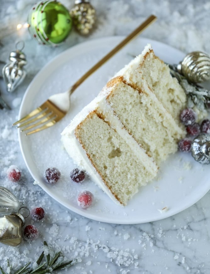 A slice of layers of light, fluffy cake, cream cheese frosting, and sugared cranberries.