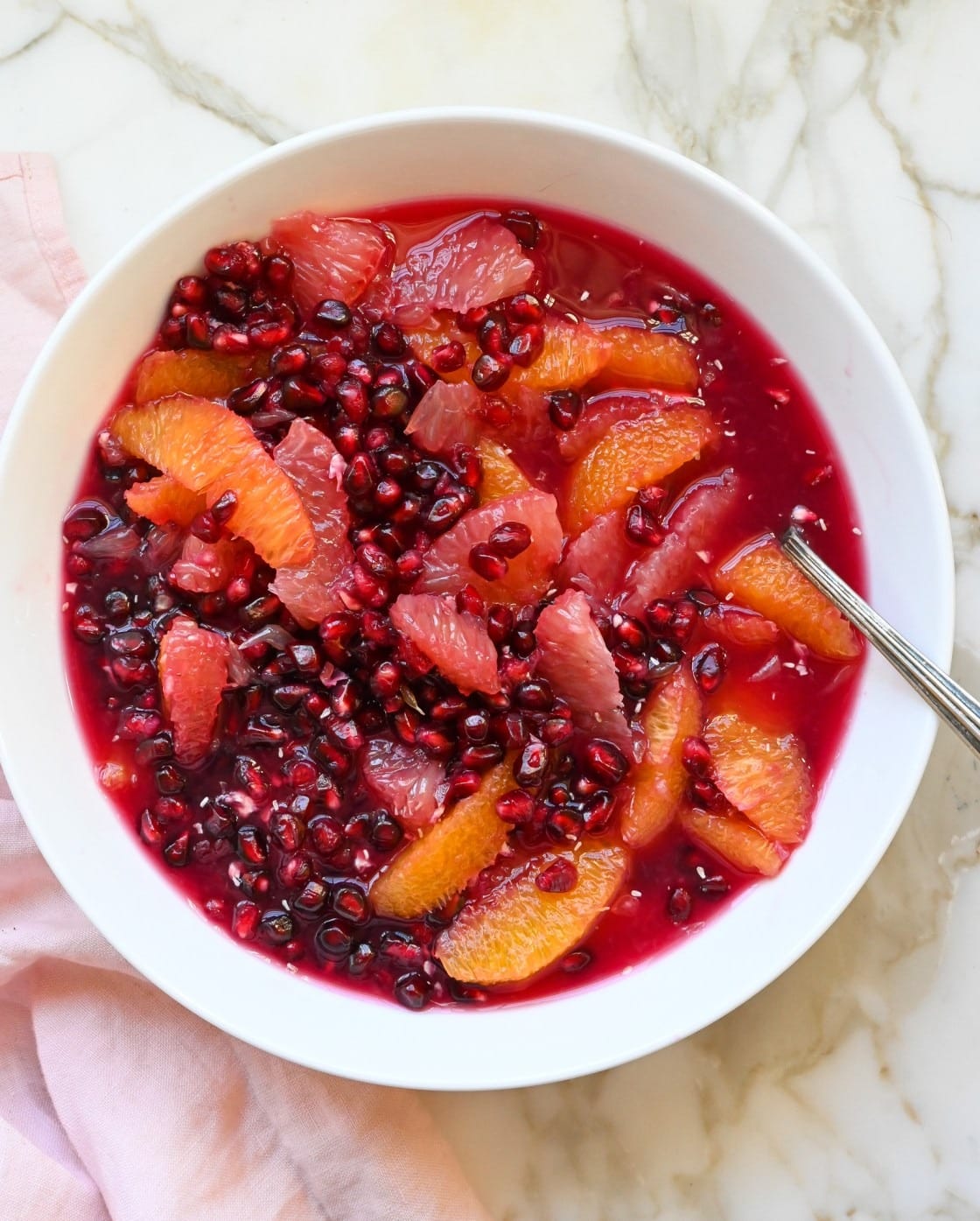 Fruit salad made with juicy pomegranate arils, grapefruits, and oranges served on a bowl