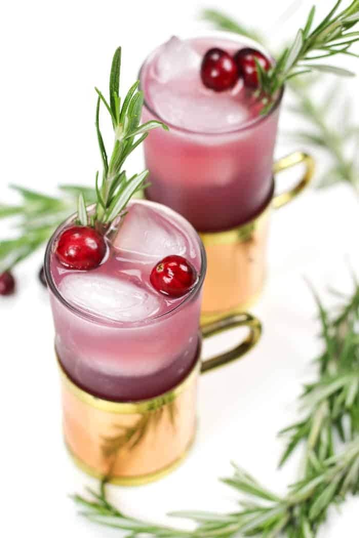 A refreshing drink with a vibrant red color, made with cranberries and infused with the aromatic flavor of rosemary.