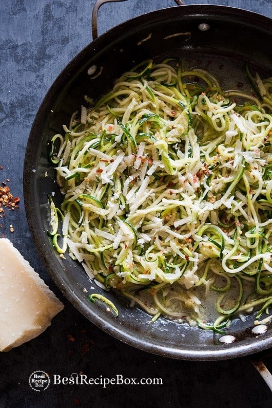 Zucchini noodles with garlic, butter, and parmesan on a pan.