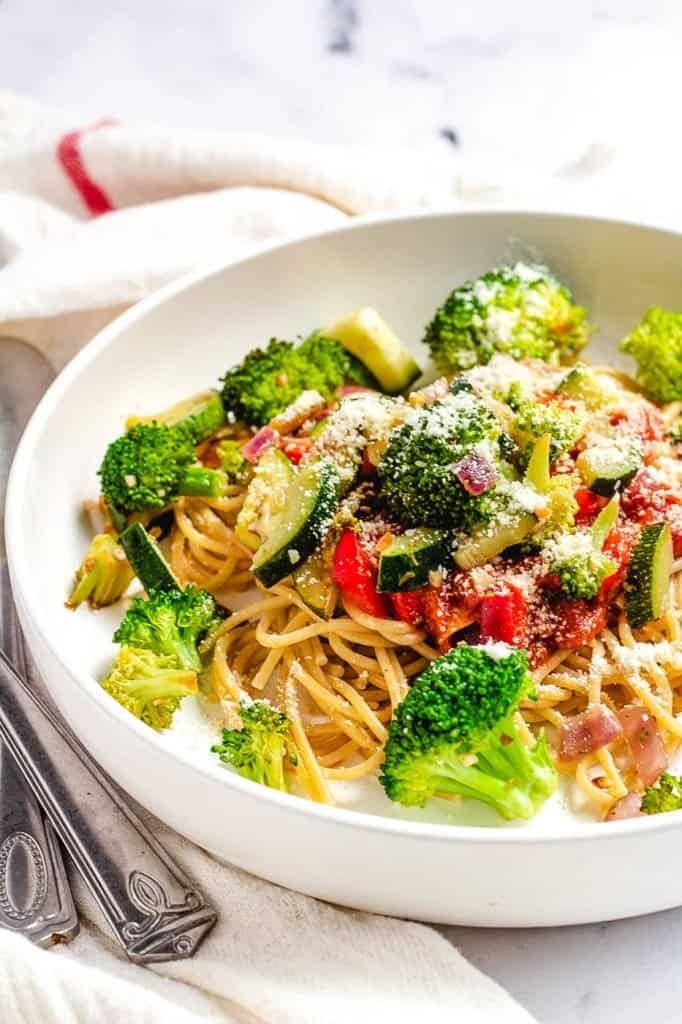 Homemade garlic pasta with broccoli, tomatoes and parmesan cheese
