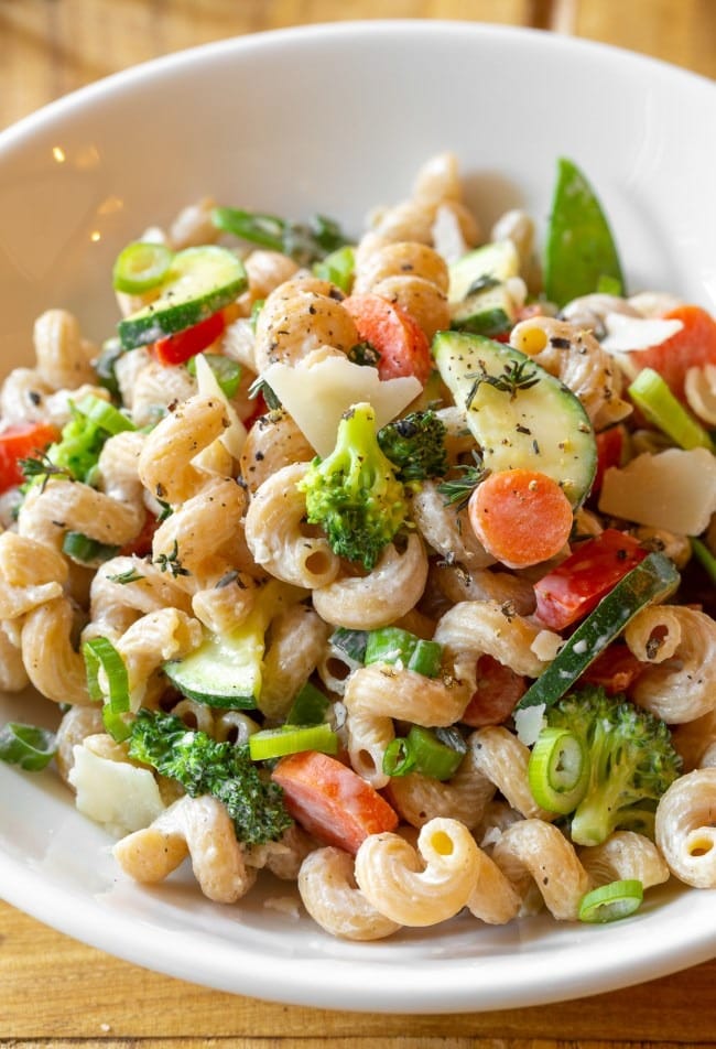 Creamy and skinny pasta primavera with broccoli, zucchini, carrots and green onions