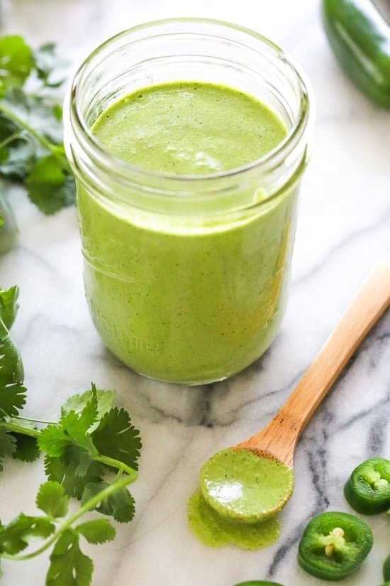 Spicy homemade aji verde in a glass jar with cilantro and hot pepper