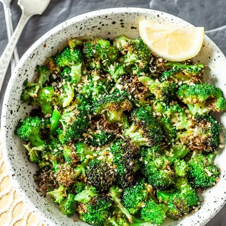 A bowl of broccoli with crispy, roasted edges. 