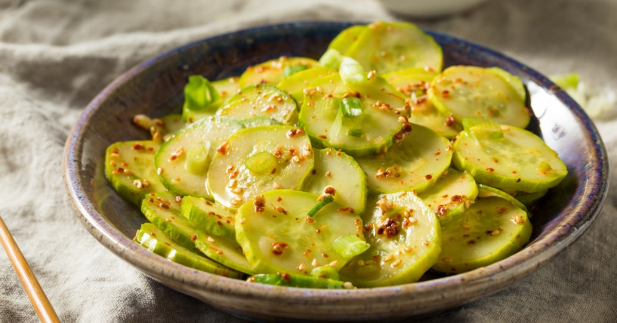 Asian cucumber salad with chili flakes and scallions.