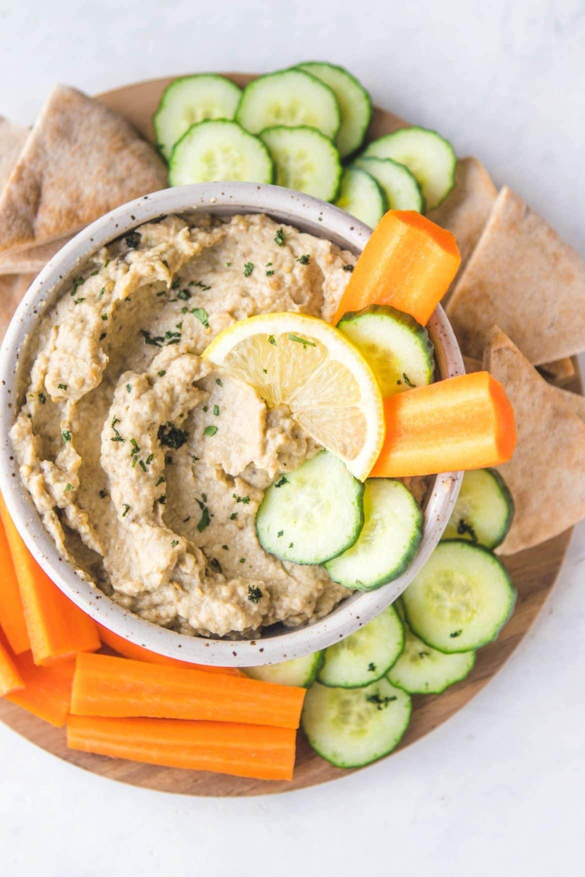 Sliced cucumber, carrots and pita bread served with baba ganoush in a bowl, 
