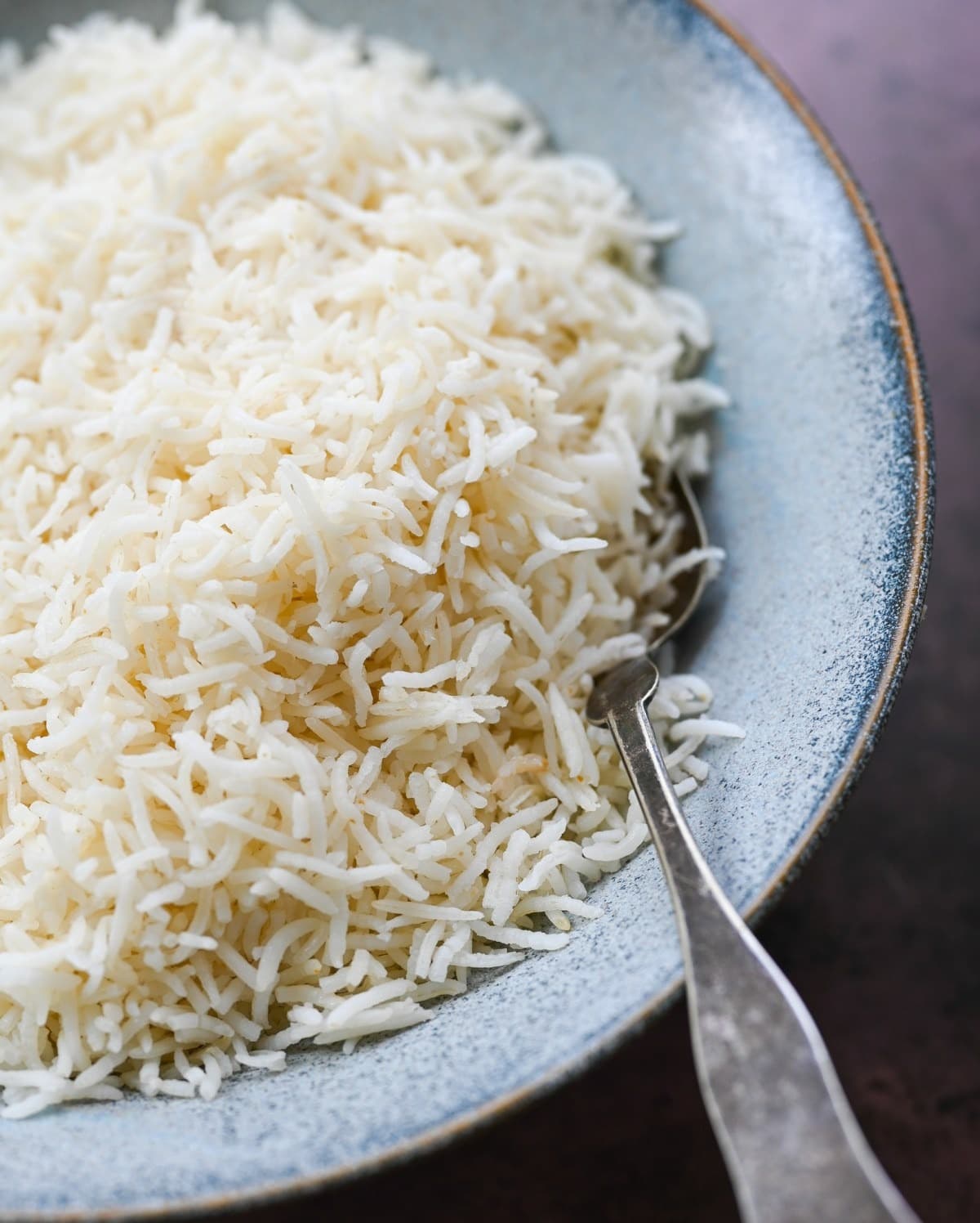 Cooked basmati rice on a plate with spoon.