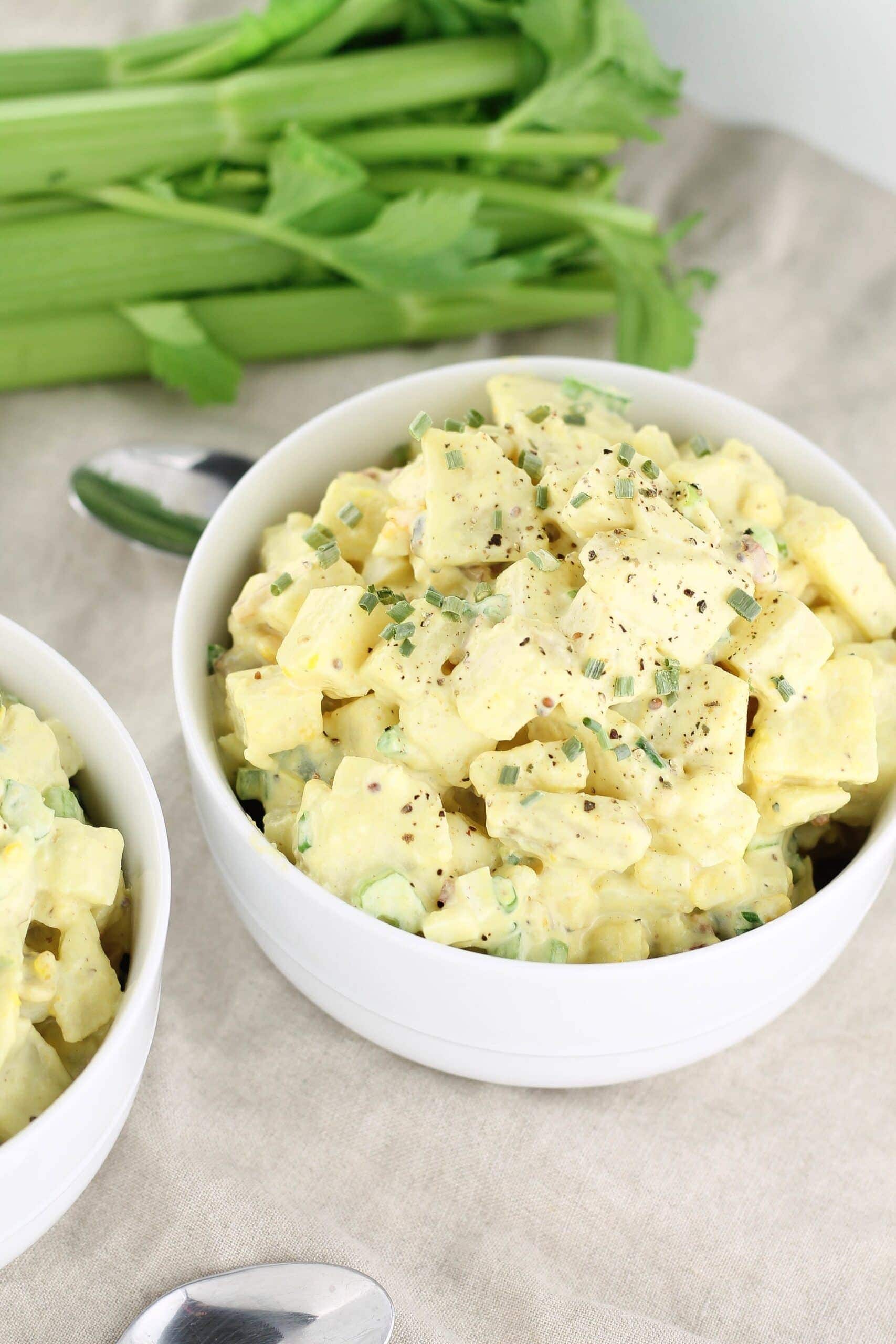 Healthy and creamy potato salad with mayonnaise, bacon and eggs in two dishes