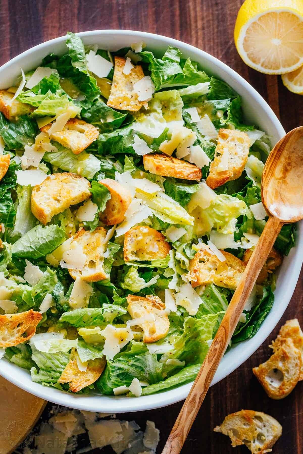 Caesar salad on a bowl with leafy greens, buttery croutons, and grated Parmesan cheese. 