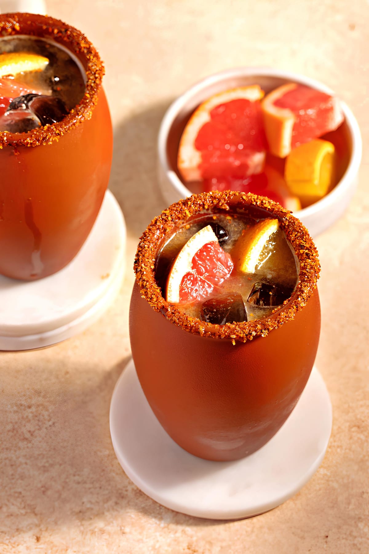 Cantarito Cocktail served Cantarito mugs with tajin on rims garnished with slices of fresh graprfruit.