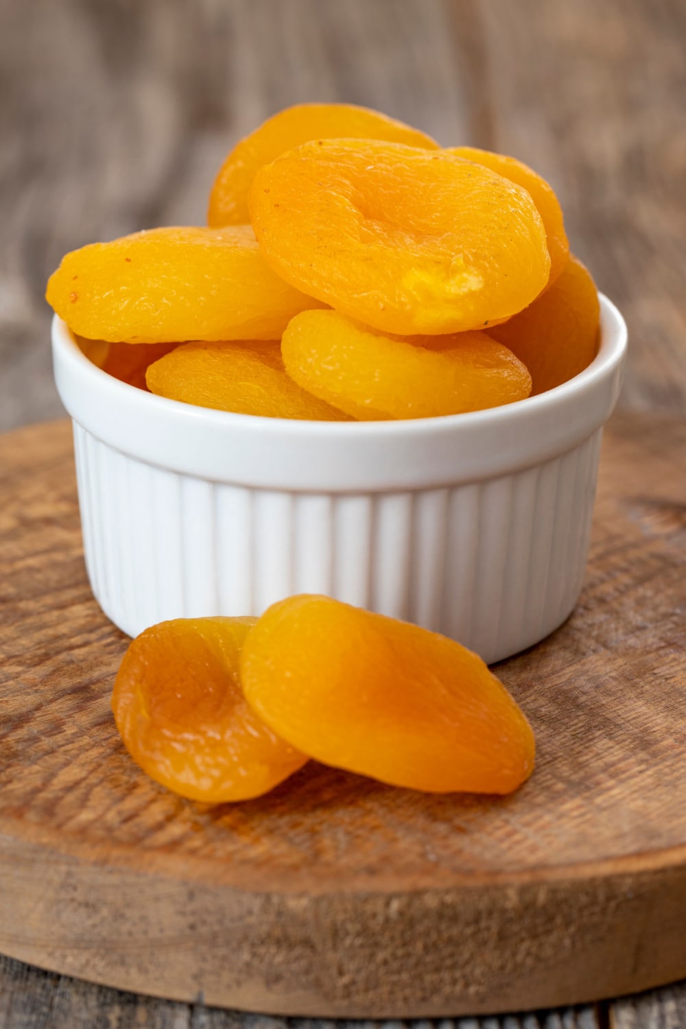 Small white bowl filled with dried apricots. 