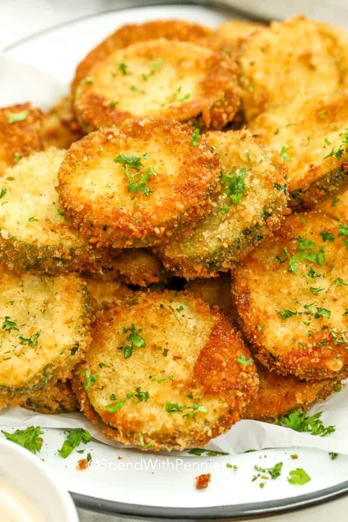 A bunch of parmesan cheese coated fried zucchini on plate.