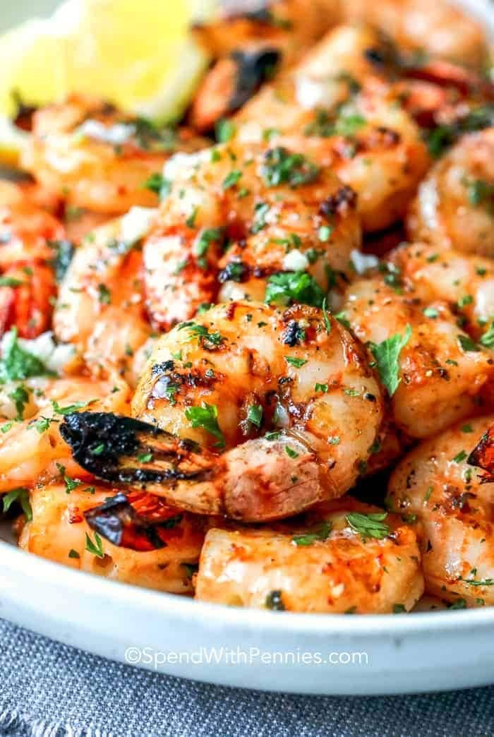 Buttered shrimp on bowl with chopped parsley leaves. 