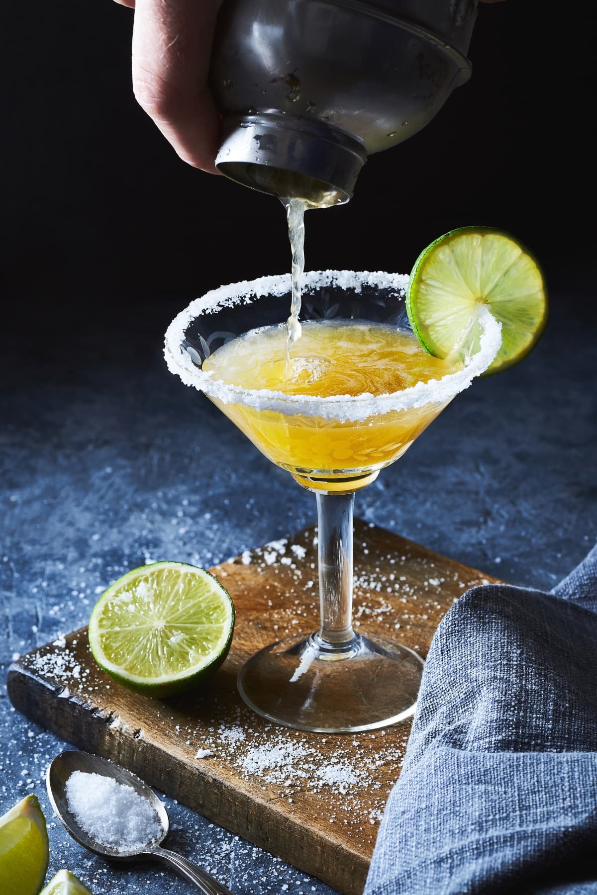 13 Shimmering Gold Cocktails to Dazzle Your Guests featuring a Gold Margarita with salted rim and lime wheel.