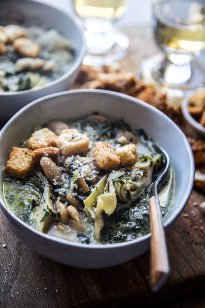 Green goddess white bean soup with croutons in a bowl with a spoon