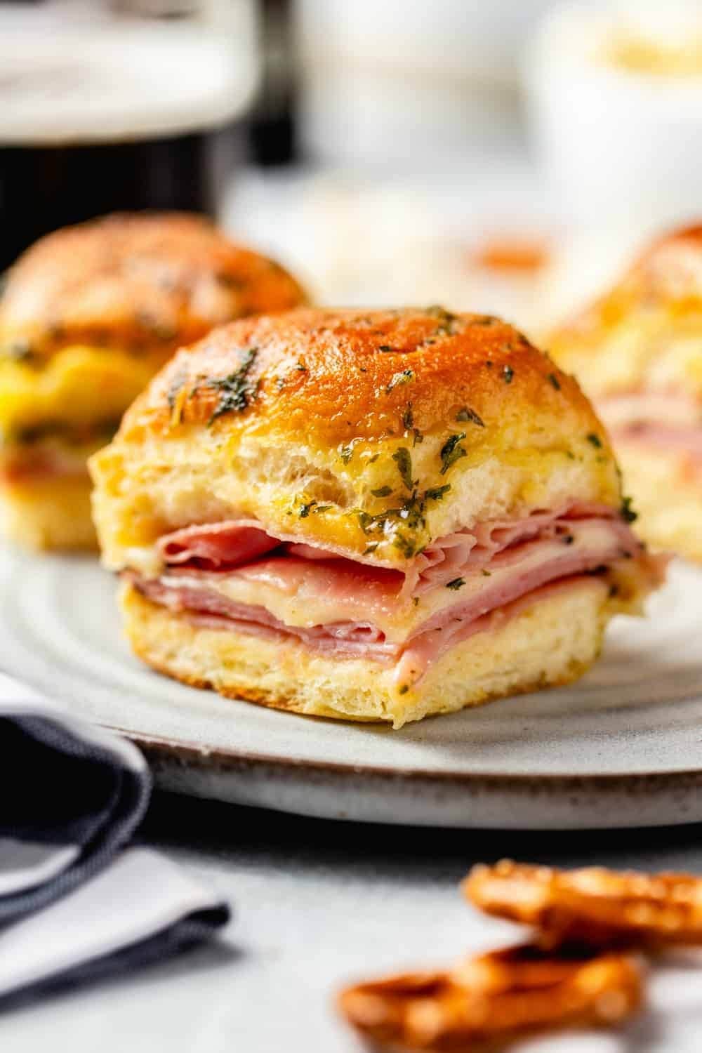 Sliders with ham and cheese filling on plate.