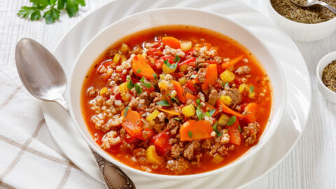 Hamburger soup in a white bowl with spoon.