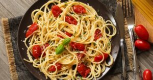 Italian pasta dish with vibrant red tomatoes and fresh basil leaves, a classic combination bursting with flavor.