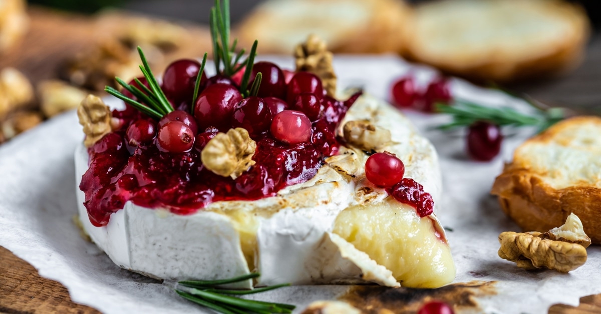 Baked Brie: A delectable dish featuring melted cheese topped with cranberries and walnuts
