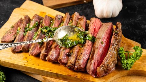 Grilled steak topped with flavorful chimichurri sauce and a medley of aromatic herbs