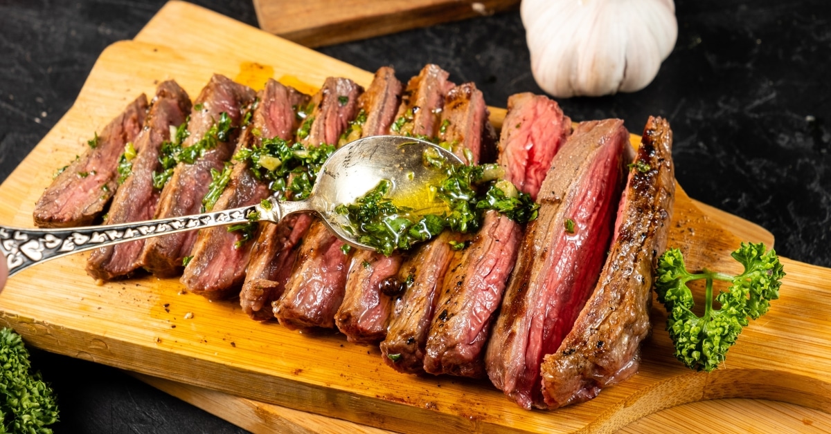 Grilled steak topped with flavorful chimichurri sauce and a medley of aromatic herbs