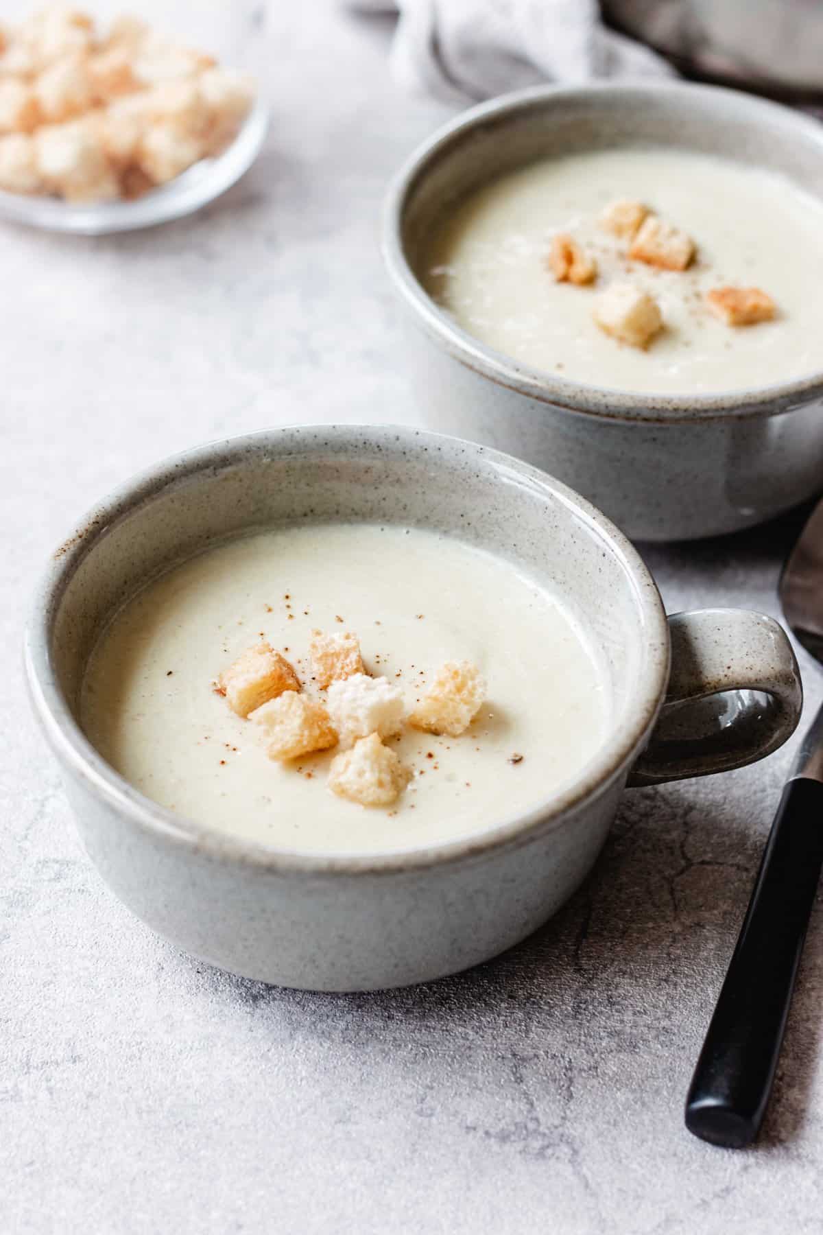 Savory and creamy sweet potato soup with croutons in a bowl with a spoon