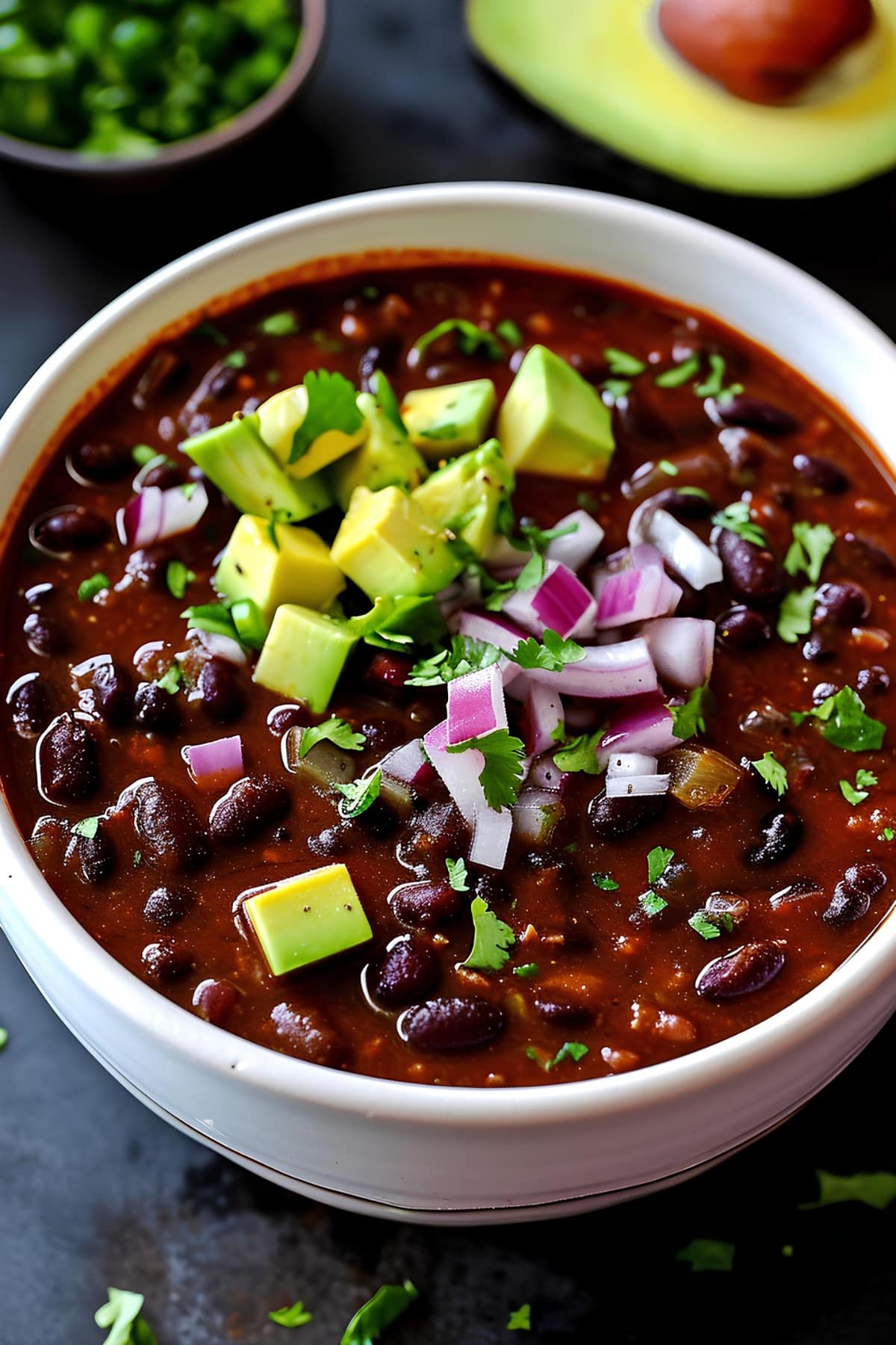 Chipotle black bean soup topped with avocados and chopped onions, a delicious and nutritious dish