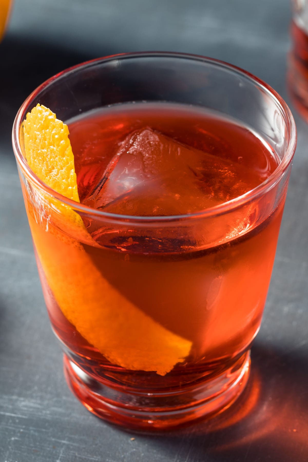 Mezcal Negroni cocktail served in a glass with ice garnished with lemon peel. 