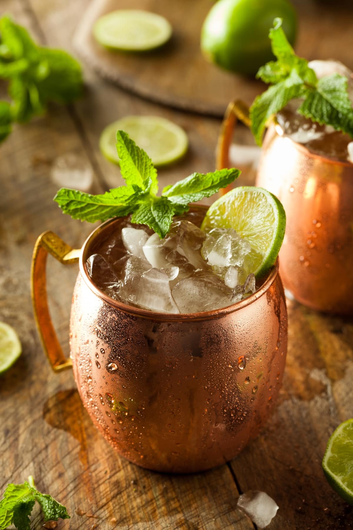 Moscow mule cocktail on ice garnished with lime wheel.