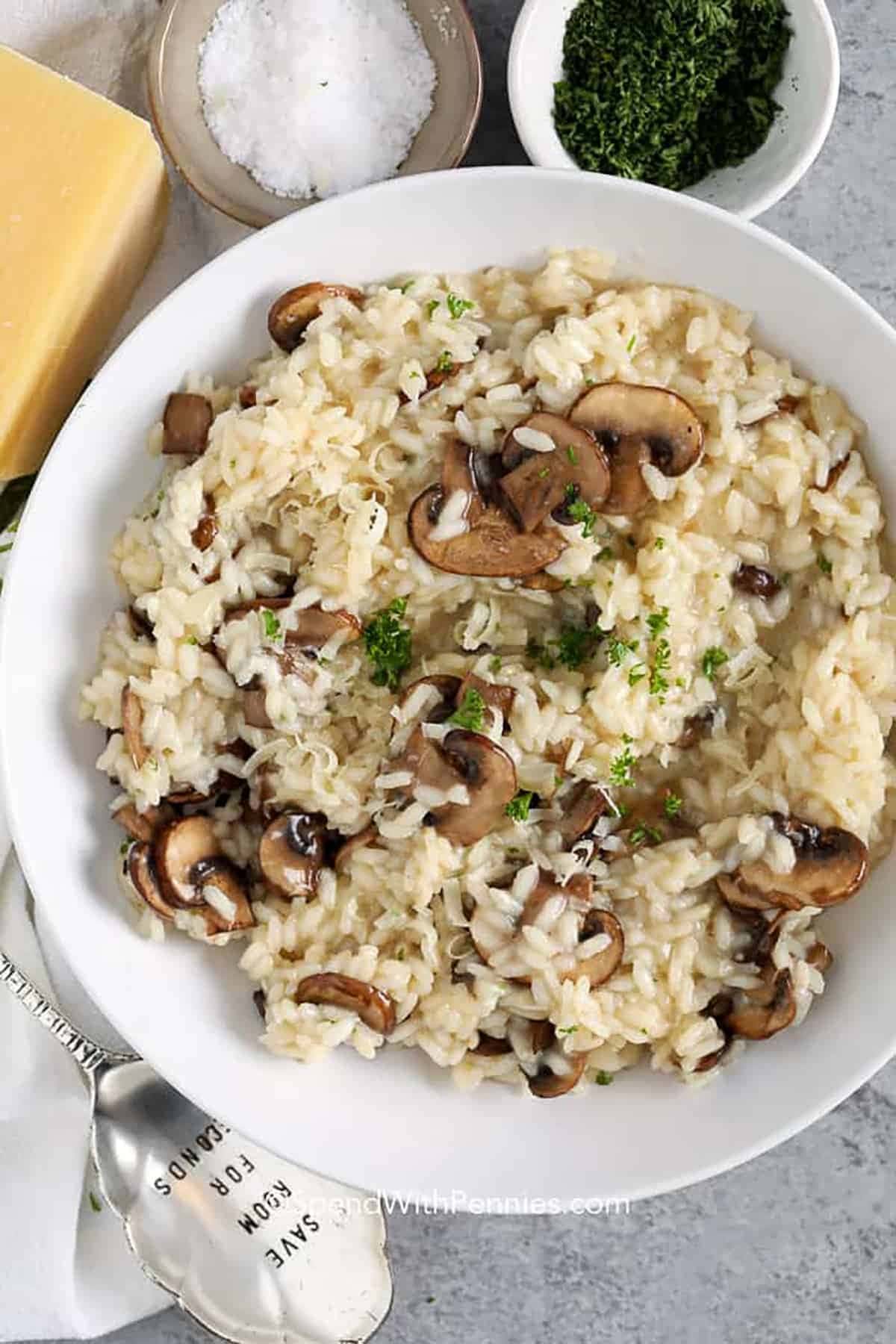 Top view of a serving of mushroom risotto on a white bowl.
