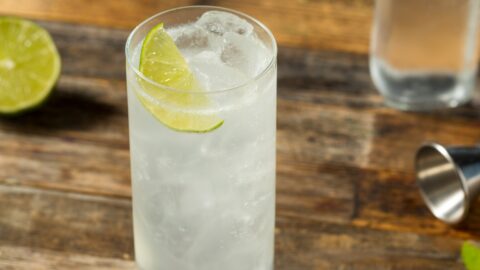 Sparkling Ranch water on a highball glass filled with ice on a wooden table.