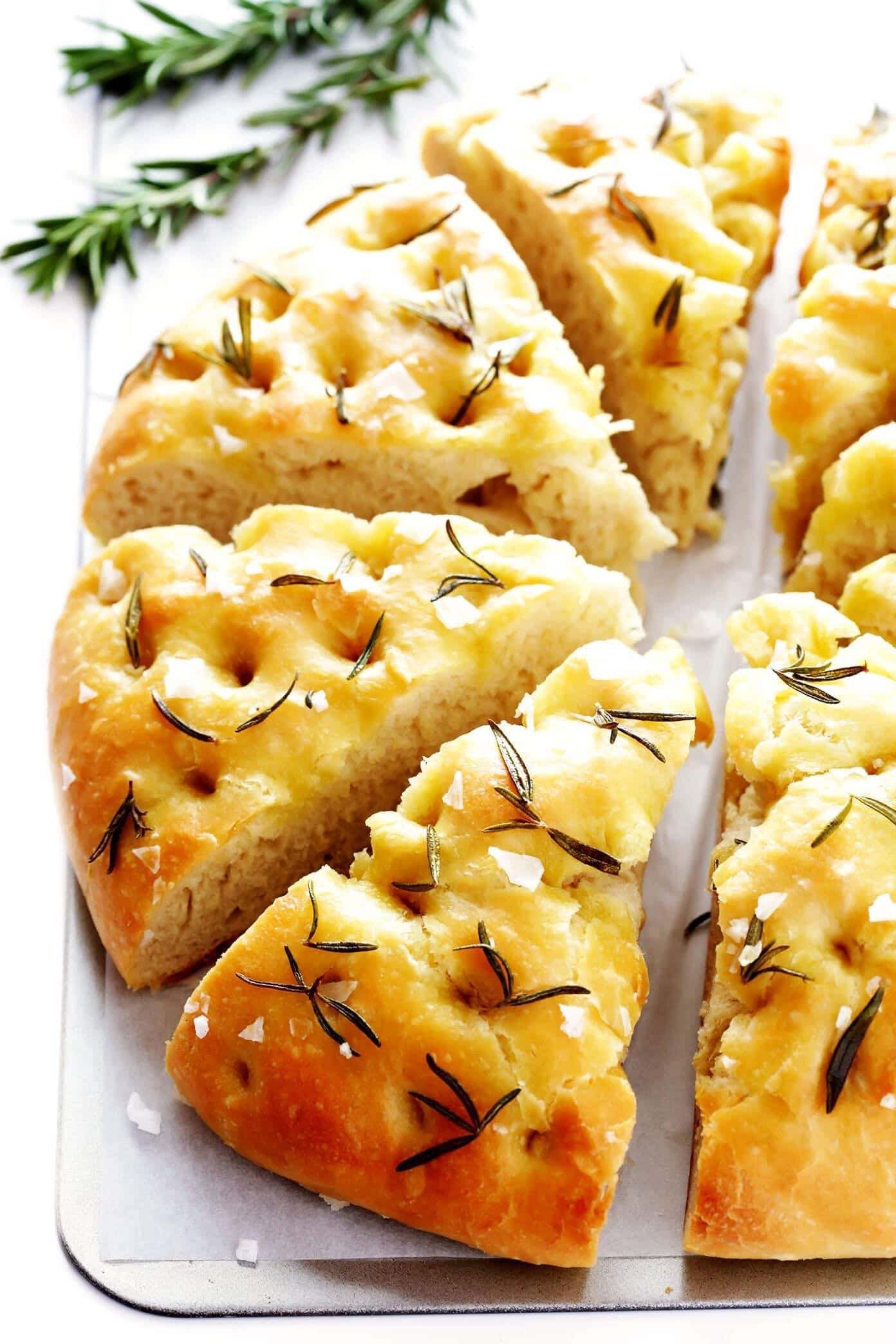 Triangle sliced focaccia bread with rosemary and drizzle of olive oil.