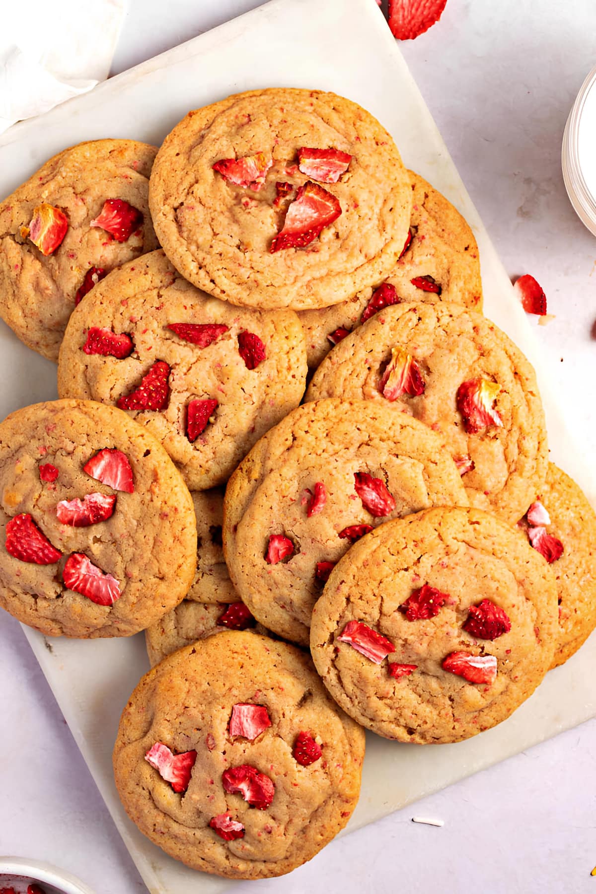 Bunch of thin cookies with strawberry bits on top. 